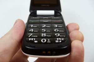 Close-up of a large button, flip-style mobile phone. 