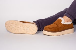 Close up of a person's feet wearing sturdy brown, cosy slippers