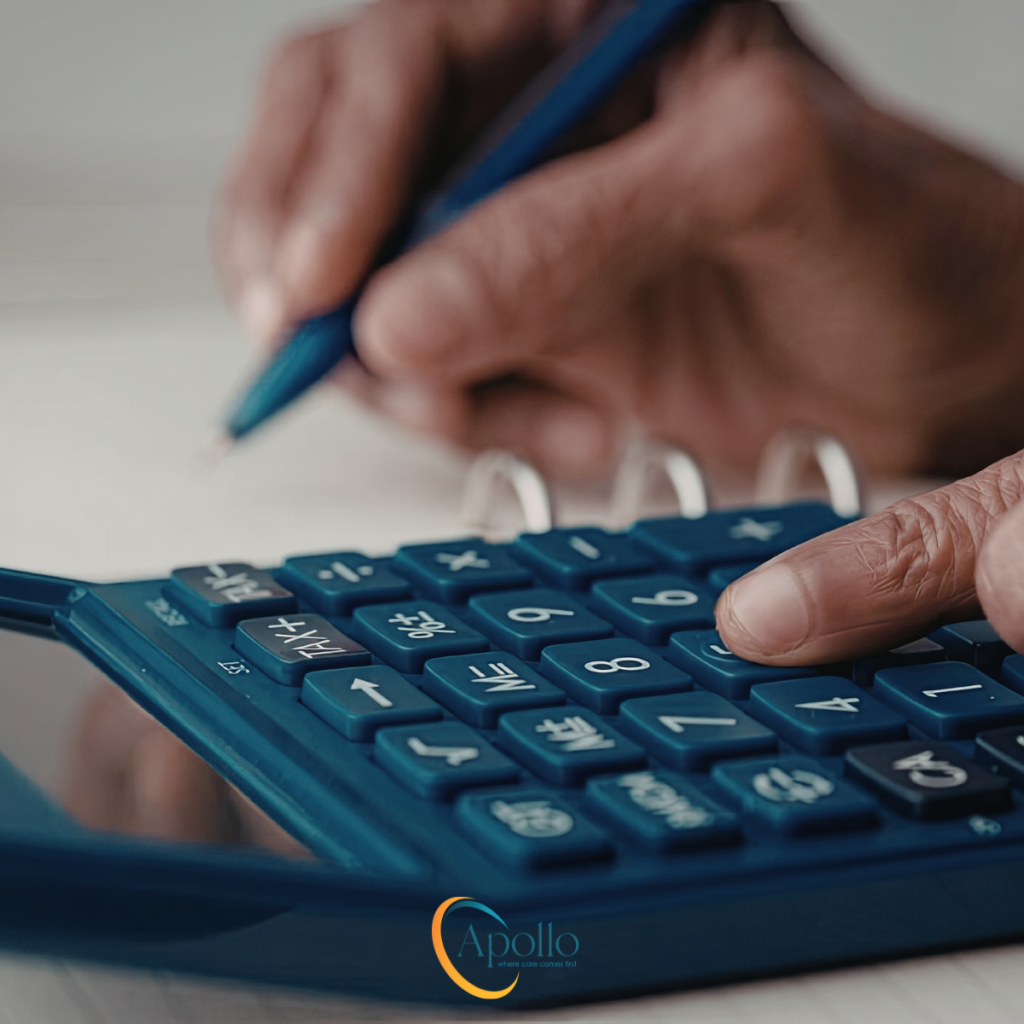 Close up of hands doing sums on a calculator.
