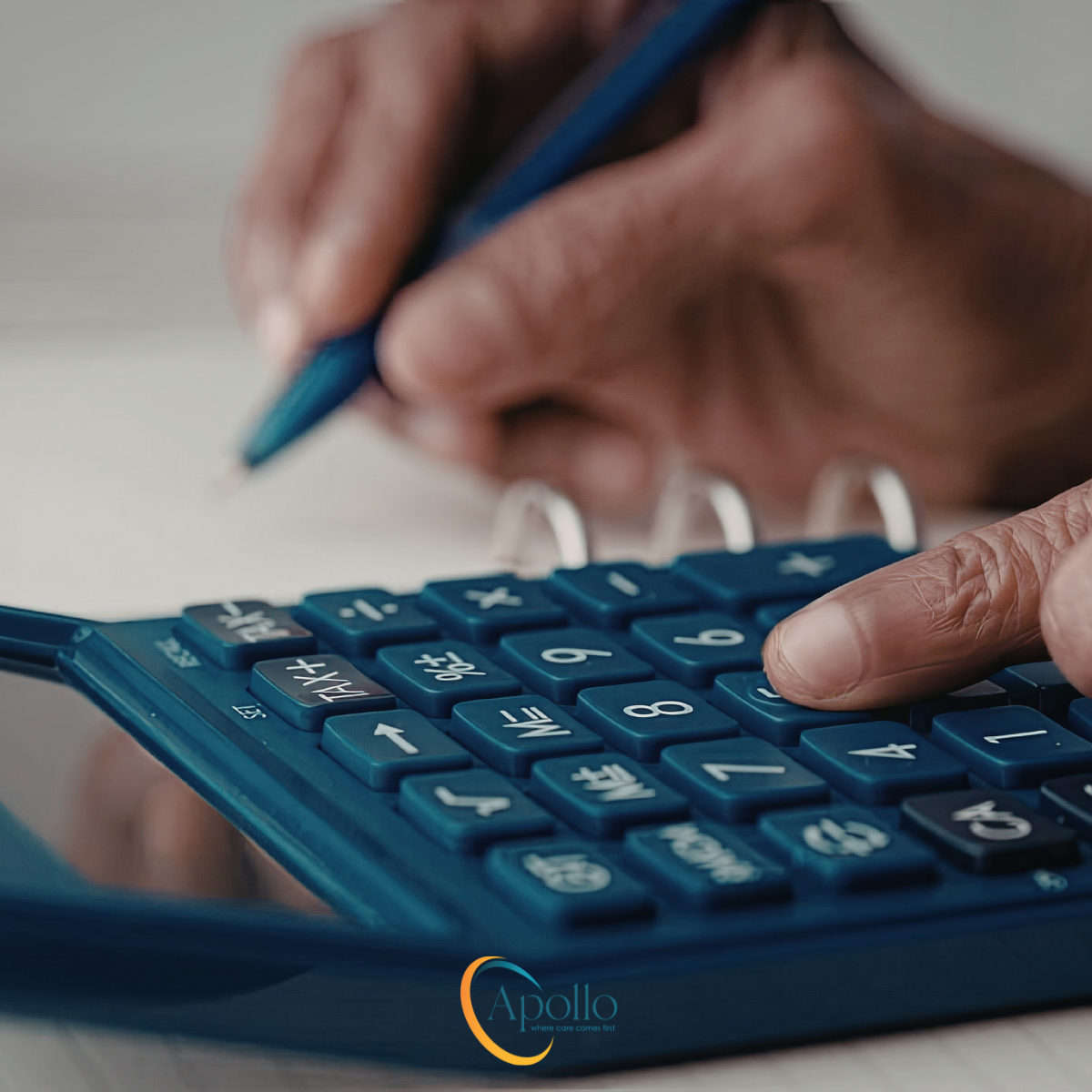 Close up of hands doing sums on a calculator.